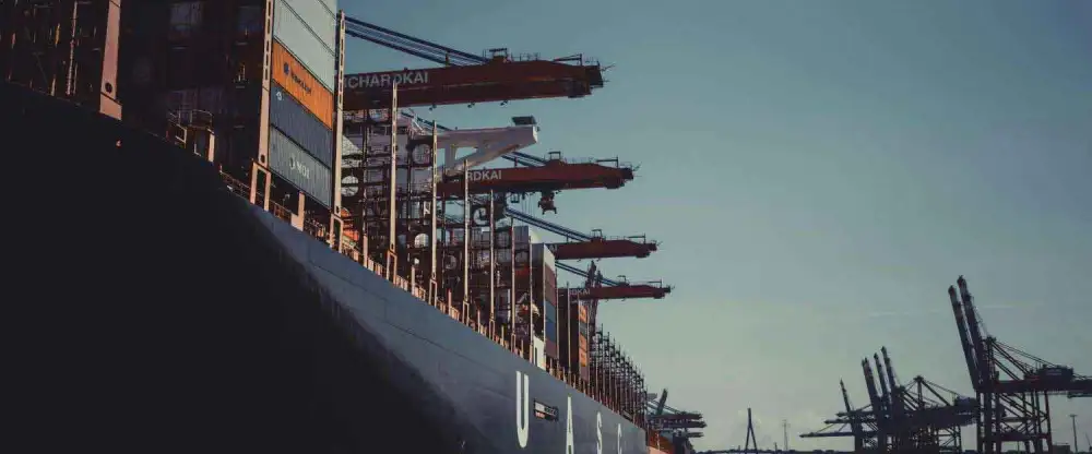 freight cargo ship on a sunny day with crains