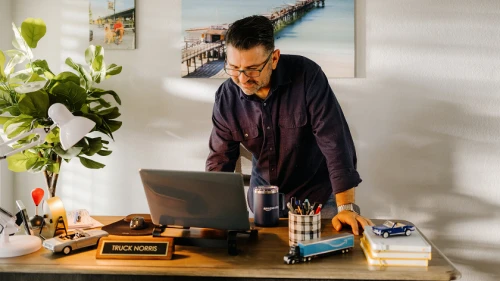 Man looking over laptop in office